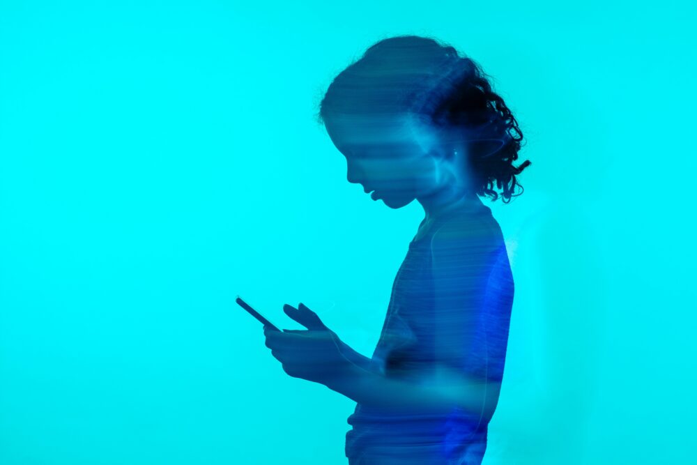 スマホを見る女性のシルエット